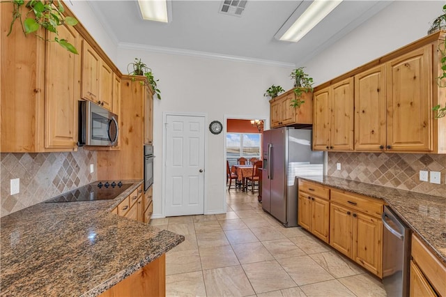 kitchen with backsplash, black appliances, crown molding, dark stone countertops, and light tile patterned flooring