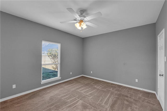 carpeted spare room featuring ceiling fan