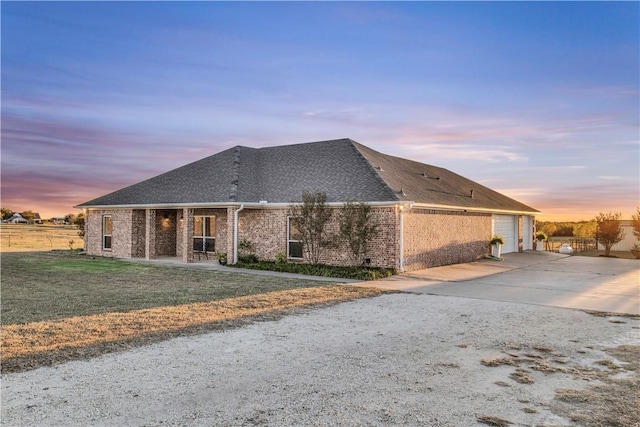 view of front of property with a garage and a lawn