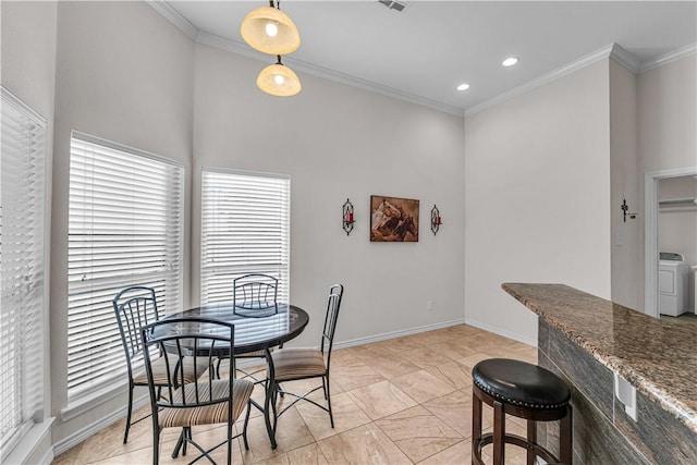 dining area with crown molding and washer / dryer