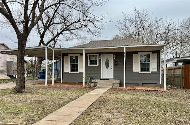 bungalow-style house with a porch, a front lawn, a shingled roof, and fence