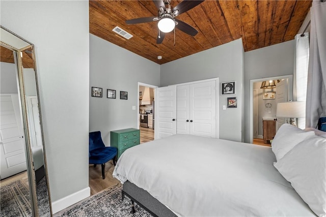 bedroom with ceiling fan, hardwood / wood-style floors, wood ceiling, and a closet