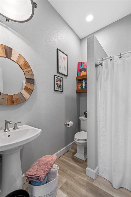 bathroom featuring hardwood / wood-style flooring and toilet