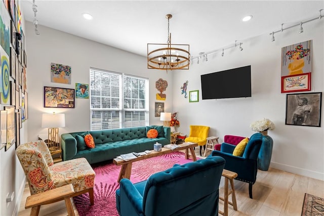 living room featuring light hardwood / wood-style floors, rail lighting, and a chandelier