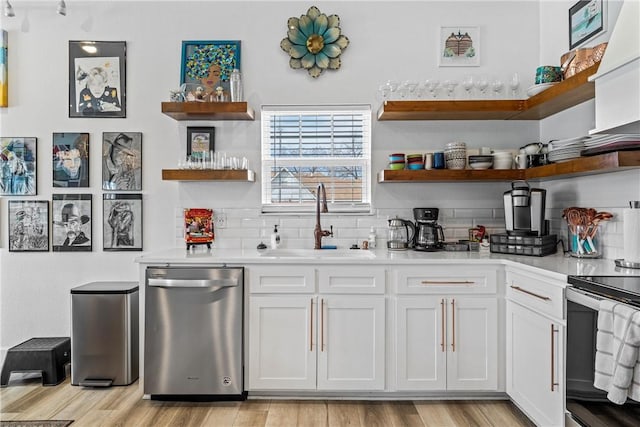 interior space featuring appliances with stainless steel finishes, sink, white cabinets, and backsplash