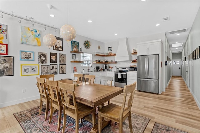 dining room featuring sink and light wood-type flooring