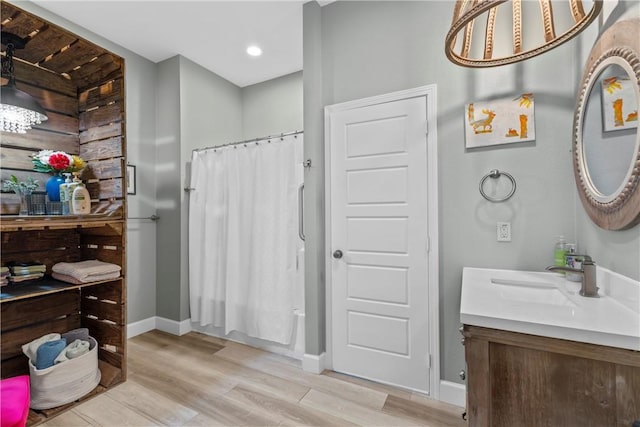 bathroom featuring hardwood / wood-style flooring, vanity, and shower / bath combination with curtain