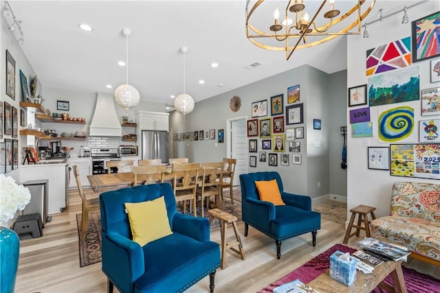 living room featuring an inviting chandelier and light wood-type flooring