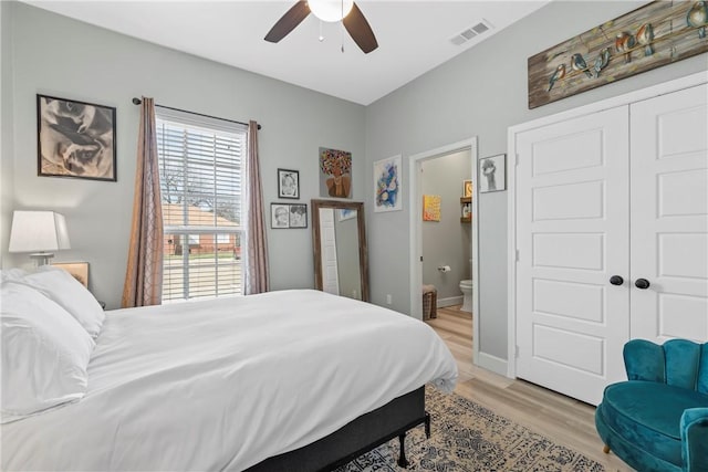 bedroom with connected bathroom, a closet, ceiling fan, and light wood-type flooring