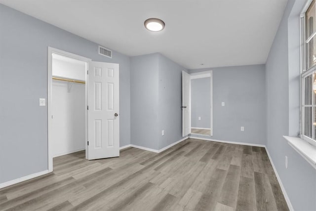 unfurnished bedroom featuring light hardwood / wood-style flooring and a closet