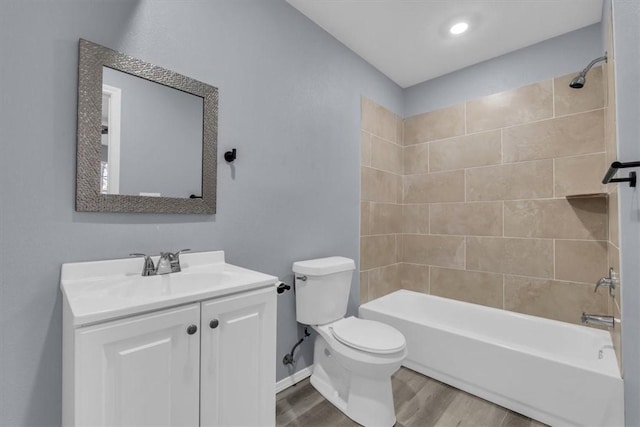 full bathroom featuring tiled shower / bath, wood-type flooring, toilet, and vanity