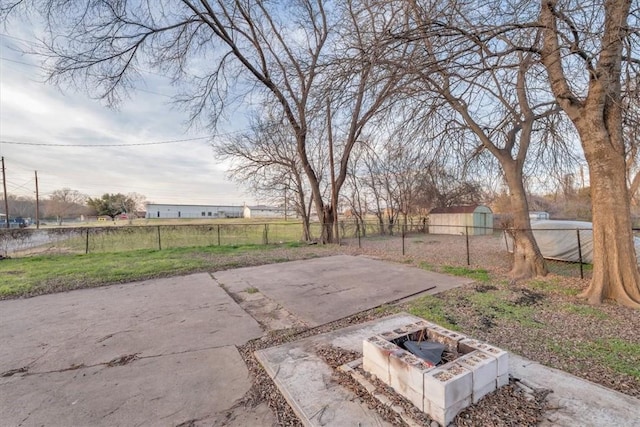 view of patio / terrace with a shed and a fire pit