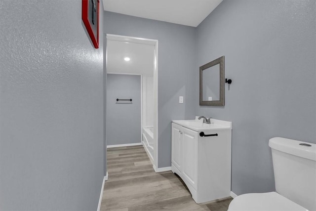 bathroom featuring vanity, hardwood / wood-style flooring, and toilet