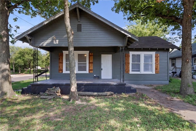 bungalow-style house with a front yard and covered porch