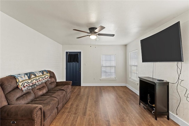 living area featuring ceiling fan, wood finished floors, and baseboards