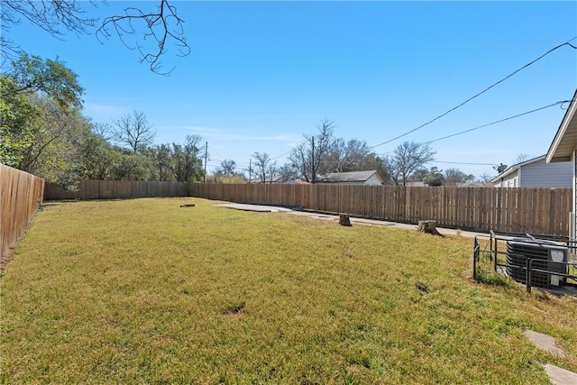 view of yard featuring a fenced backyard and central AC