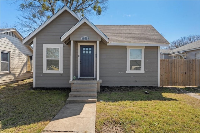 bungalow-style house with a front yard and fence