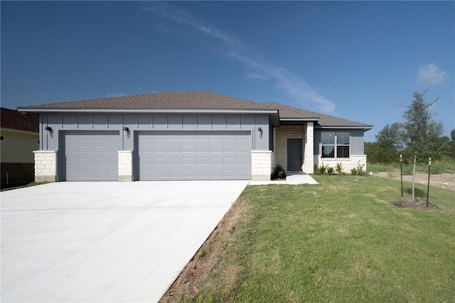 prairie-style home featuring concrete driveway, a front lawn, board and batten siding, and an attached garage