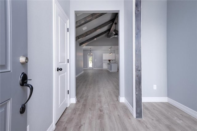 corridor with lofted ceiling with beams and light hardwood / wood-style floors