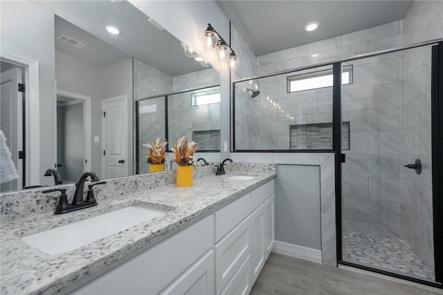 bathroom with vanity, wood-type flooring, and an enclosed shower