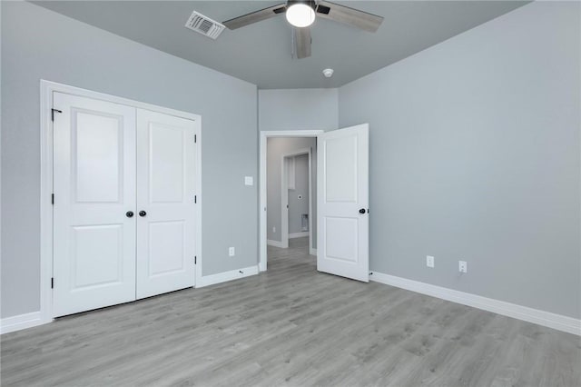 unfurnished bedroom with ceiling fan, a closet, and light wood-type flooring