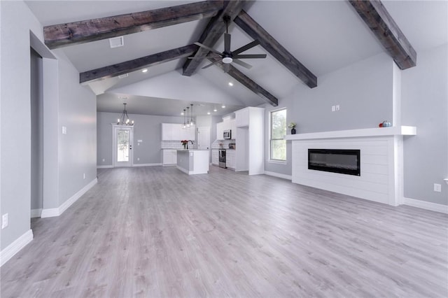 unfurnished living room featuring vaulted ceiling with beams, light hardwood / wood-style floors, and ceiling fan