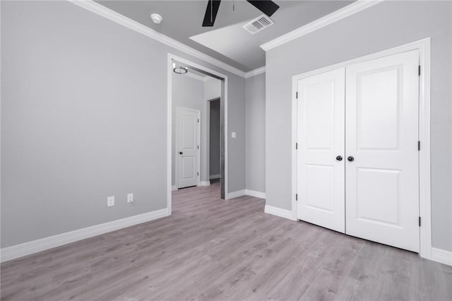 unfurnished bedroom with crown molding, a closet, ceiling fan, and light wood-type flooring