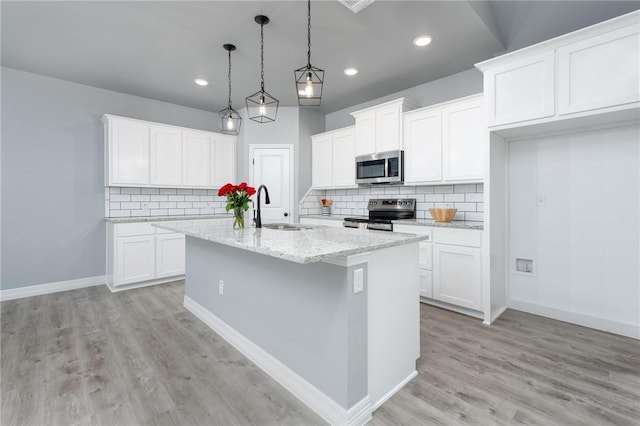 kitchen with white cabinets, pendant lighting, stainless steel appliances, and sink