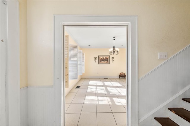 doorway to outside featuring light tile patterned flooring and a notable chandelier