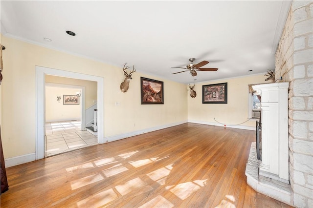 unfurnished living room featuring ceiling fan, ornamental molding, and light hardwood / wood-style floors