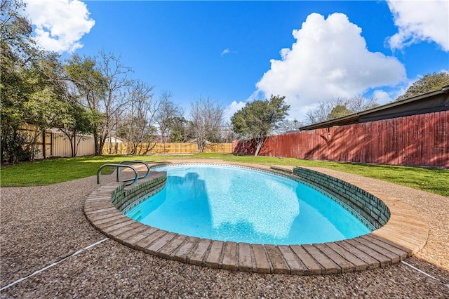 view of swimming pool with a yard