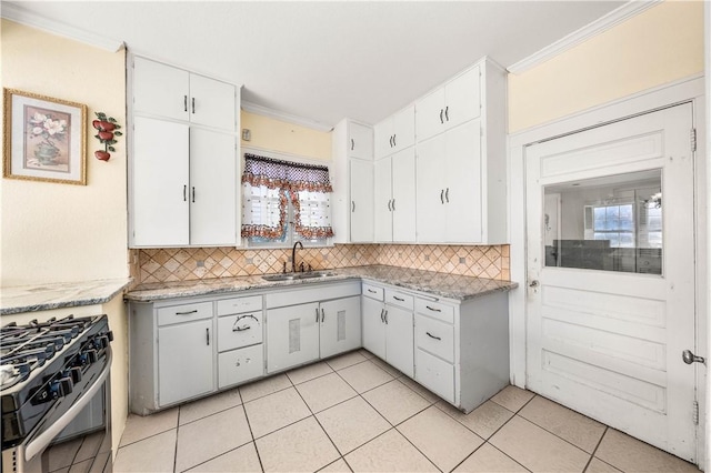 kitchen with stainless steel range with gas cooktop, sink, and white cabinets