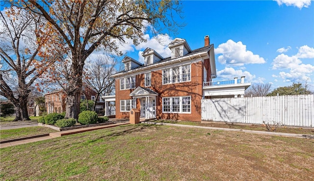 colonial-style house featuring a front yard