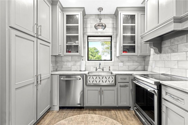 kitchen with premium range hood, stainless steel appliances, dark wood-type flooring, pendant lighting, and gray cabinets