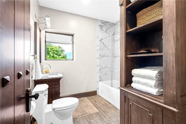 full bathroom with hardwood / wood-style floors, vanity, toilet, and tiled shower / bath