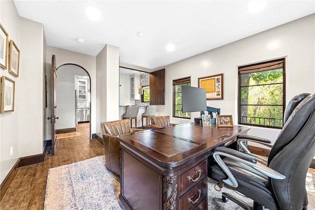 home office with dark hardwood / wood-style floors