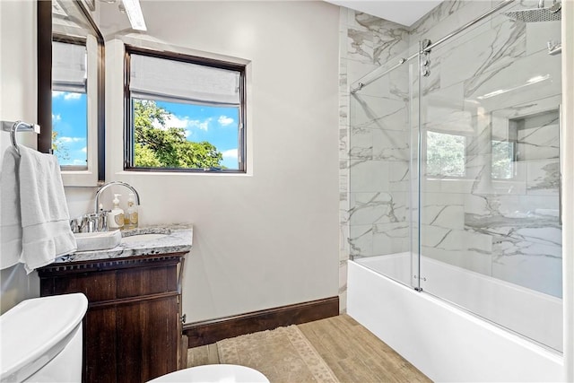 full bathroom with enclosed tub / shower combo, toilet, wood-type flooring, and vanity