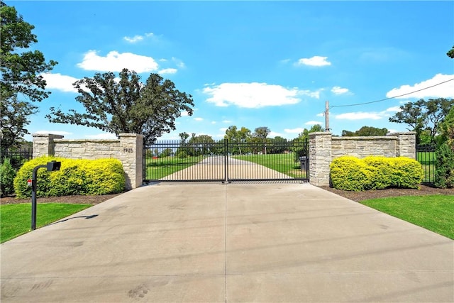 view of gate with a yard