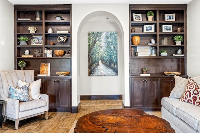 bar featuring dark brown cabinetry and light hardwood / wood-style floors