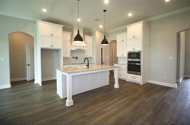 kitchen featuring white cabinetry, an island with sink, dark hardwood / wood-style floors, and appliances with stainless steel finishes