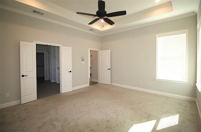 unfurnished bedroom featuring carpet, ceiling fan, crown molding, and a tray ceiling