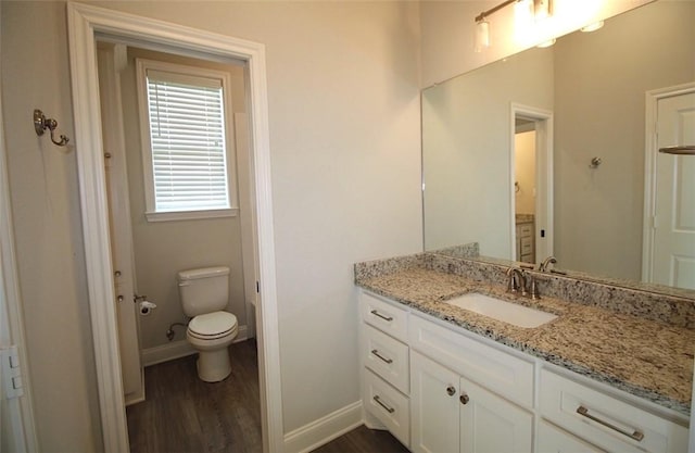 bathroom featuring vanity, hardwood / wood-style flooring, and toilet