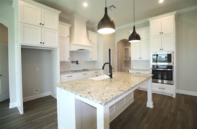 kitchen with pendant lighting, a center island with sink, sink, white cabinetry, and stainless steel appliances