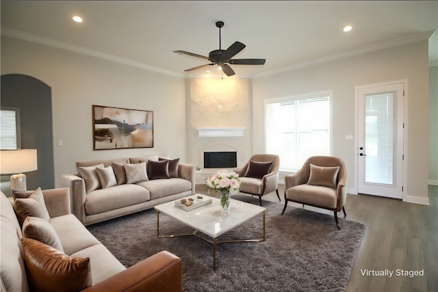 living room with crown molding, ceiling fan, and dark wood-type flooring