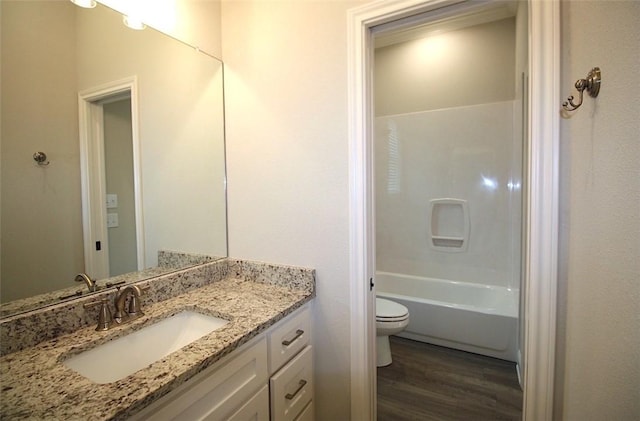 full bathroom featuring vanity, hardwood / wood-style flooring, toilet, and  shower combination