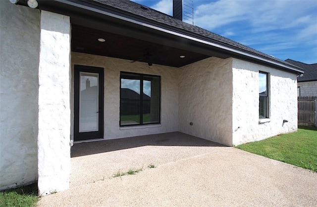 rear view of house with ceiling fan, a patio area, and a yard