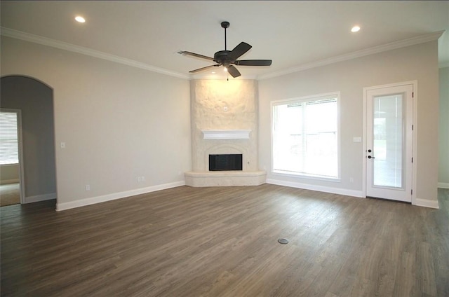 unfurnished living room featuring a fireplace, ornamental molding, ceiling fan, and dark wood-type flooring