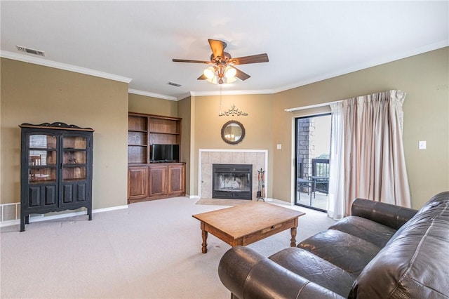 carpeted living room with crown molding, a fireplace, and ceiling fan