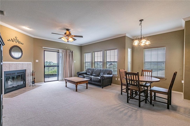 carpeted living room featuring plenty of natural light, a fireplace, ceiling fan with notable chandelier, and a textured ceiling