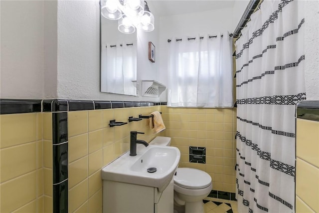 bathroom with a shower with shower curtain, tile patterned floors, vanity, tile walls, and toilet